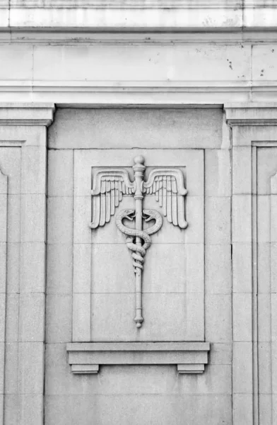 Caduceus bas-relief on vintage building — Stock Photo, Image