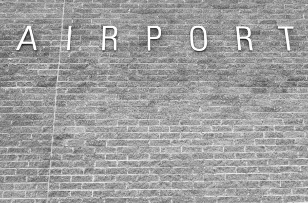 Generic airport sign on brick wall — Stock Photo, Image