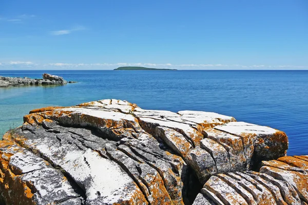 stock image Rocky coast with island horizon