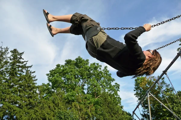 Stock image Woman swinging high on swing set