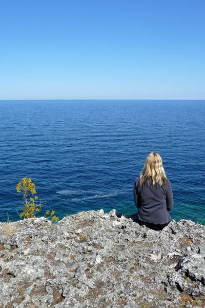 Szőke nő pihentető cliff edge — Stock Fotó