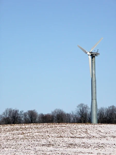 Wind generator on winter farmland Stock Photo