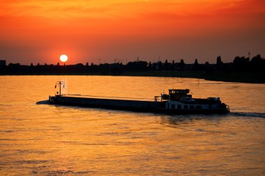 Barge with cargo at sunset clipart