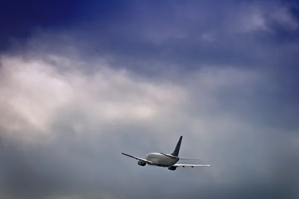 Düsenflugzeug gegen stürmischen Himmel — Stockfoto