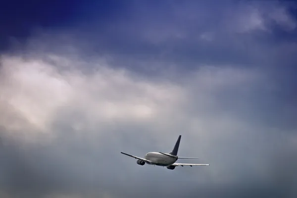 Passagiersvliegtuig tegen stormachtige hemel Stockfoto