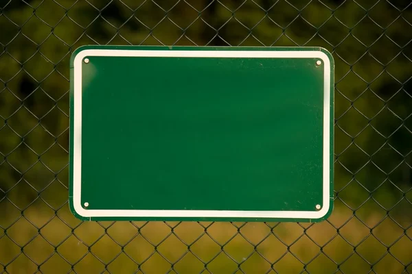 Boş yeşil işaretli bir çit — Stok fotoğraf