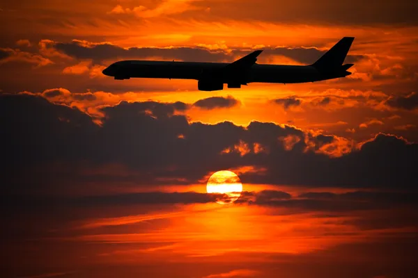 Vliegtuig silhouet tegen zon instellen — Stockfoto