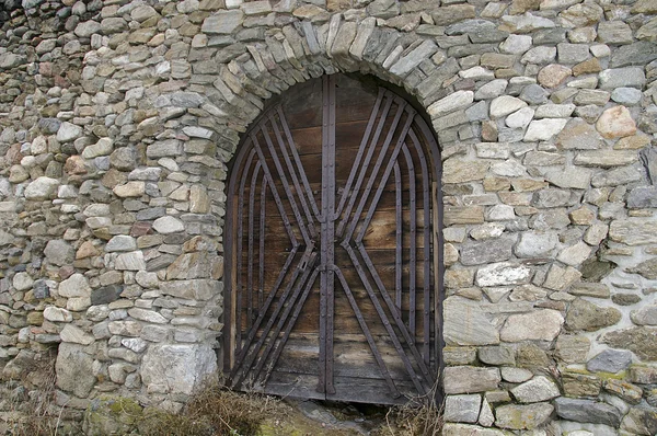 Drewno bramy zamku na kamienny mur — Zdjęcie stockowe