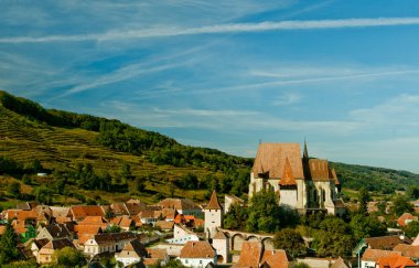 Fortified church over village clipart