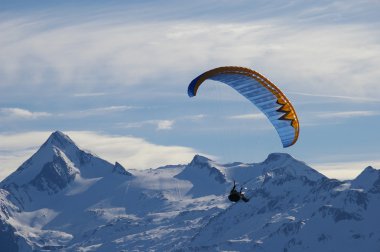 Paragliding in winter over mountain clipart