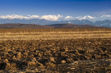 Mountain range snow peaks plowed field clipart