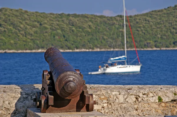 Old cannon at seaside with blue water — Stock Photo, Image
