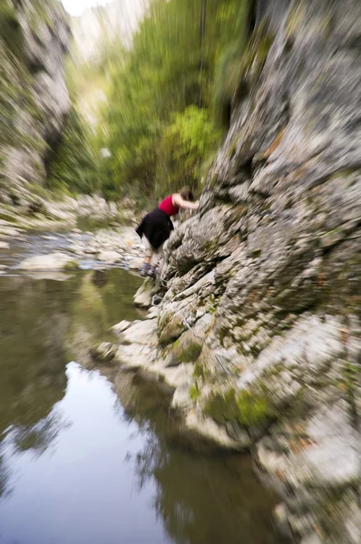 Молодые женщины перелезают через горную реку — стоковое фото