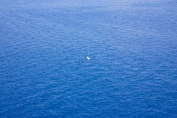 Un solo barco navegando en un vasto océano — Foto de Stock