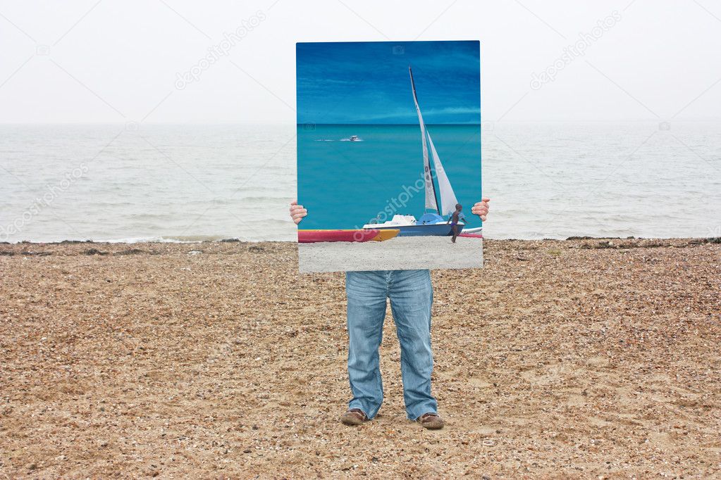 Man holds trpoical photo on beach