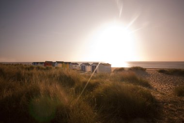 Beach huts at southwold at dawn clipart