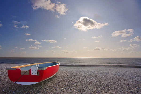 Красная лодка на пляже — стоковое фото
