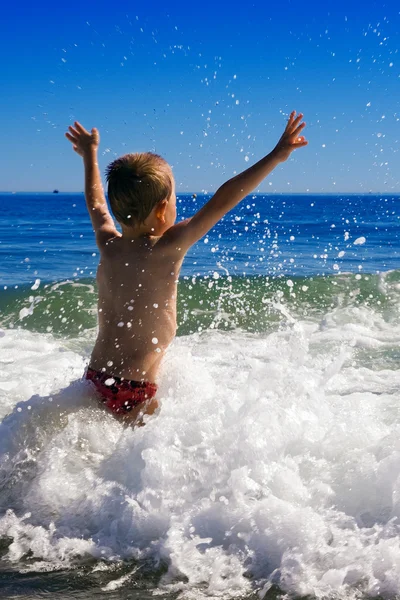 Kleinkind spielt in den Wellen — Stockfoto