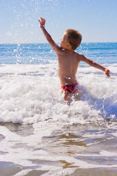 Malé dítě hrající si ve vlnách — Stock fotografie