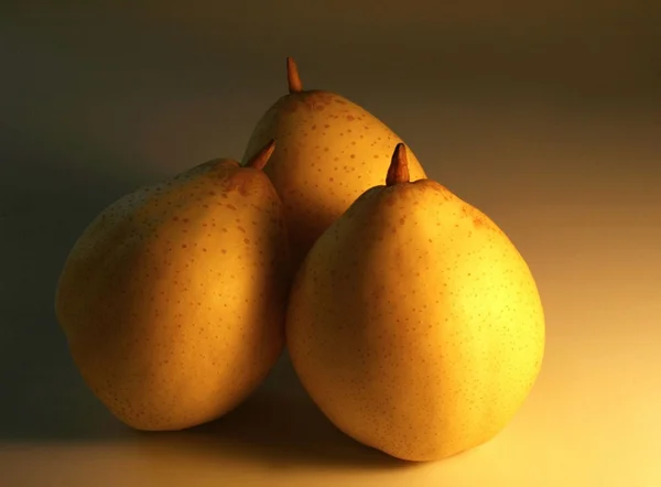 Three pears in golden light — Stock Photo, Image