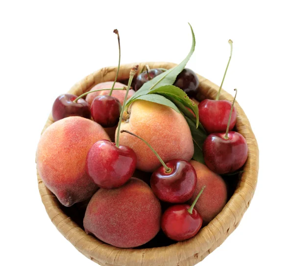 Peaches and cherries in a basket — Stock Photo, Image