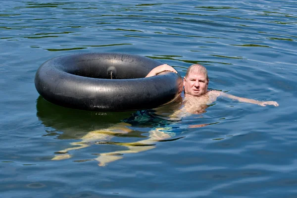 Man in water met buis — Stockfoto