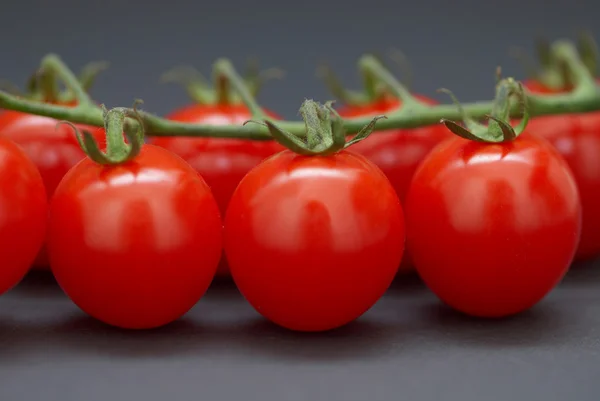 Siyah arkaplanda kiraz domatesleri. — Stok fotoğraf