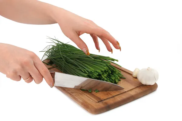 Vrouwelijke handen snijden groene ui — Stockfoto