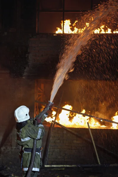 Пожарный борется с огнем — стоковое фото