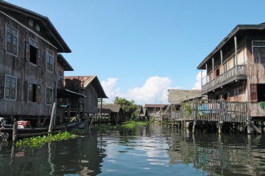 Stilt houses on river in Thailand clipart