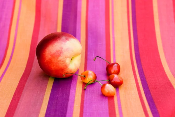 Ovoce na zářivě pruhované tkaniny — Stock fotografie