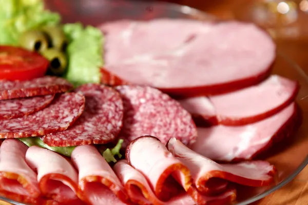 Cutting sausage and cured meat — Stock Photo, Image