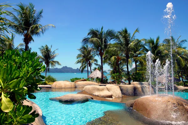 Zwembad en tropisch strand — Stockfoto