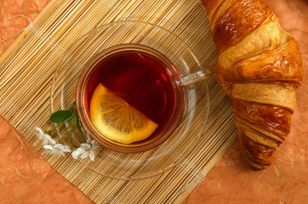 Tea with lemon and croissant — Stock Photo, Image
