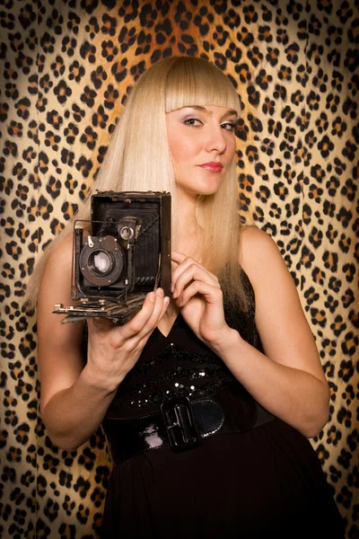 Beautiful blonde girl with a camera — Stock Photo, Image