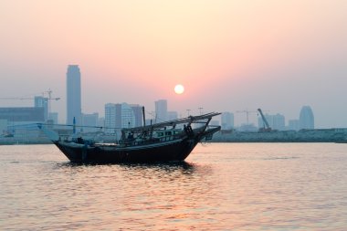 Bahrain city silhouette and fishing dhow clipart