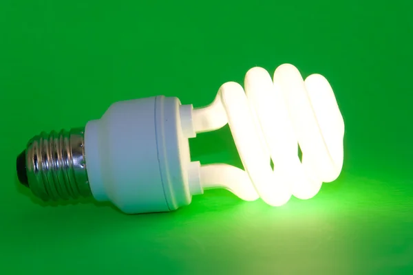 stock image Power-saving light-bulb on green