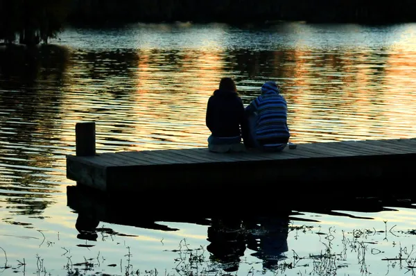Couple on Dock at Sunset Image En Vente