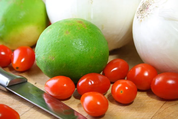 Cebolas, tomates cereja e limas — Fotografia de Stock