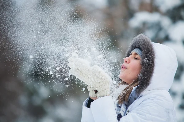 Mulher bonita soprando na neve — Fotografia de Stock