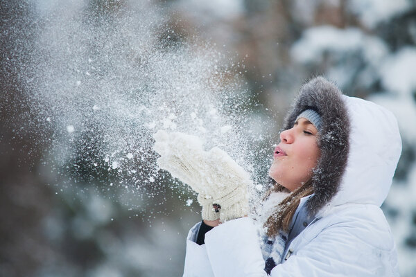Красивая женщина, дующая в снег
