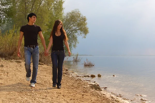 Yong couple on the bank of a river — Stock Photo, Image