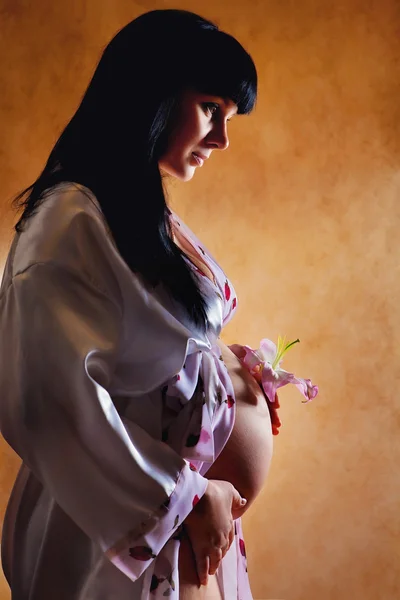 Piękna kobieta w ciąży z lily. — Zdjęcie stockowe