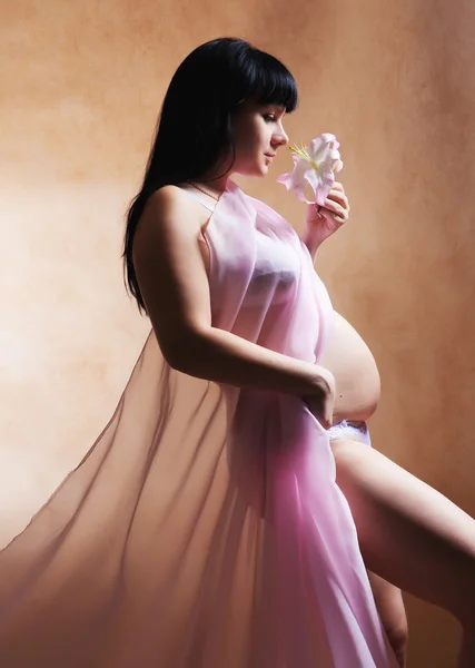 Mooie zwangere vrouw met lelie. — Stockfoto