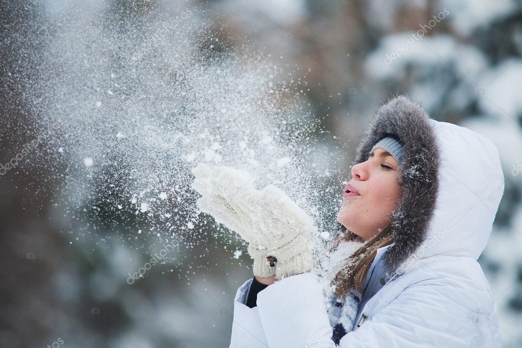 Красивая женщина, дующая в снег
