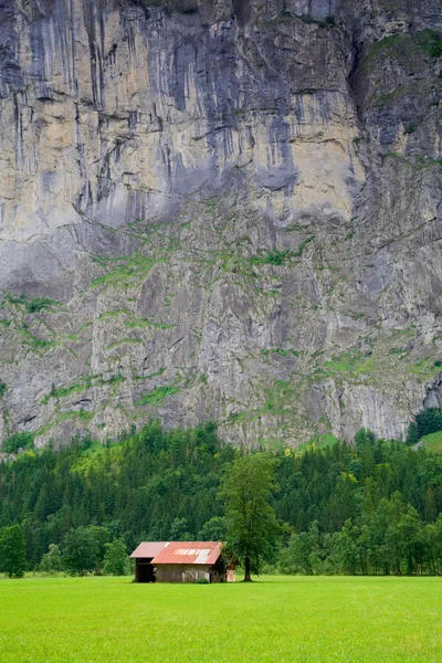 Амбар рядом с крутой скалистой горой — стоковое фото