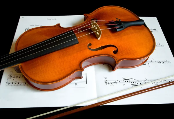 小提琴和音乐工作表上的一把弓 — 图库照片