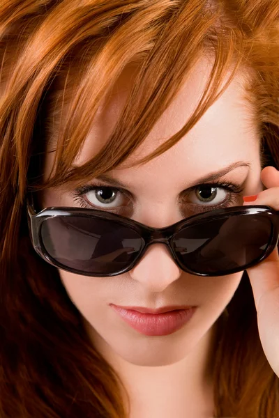 Senhora olhando sobre óculos de sol — Fotografia de Stock