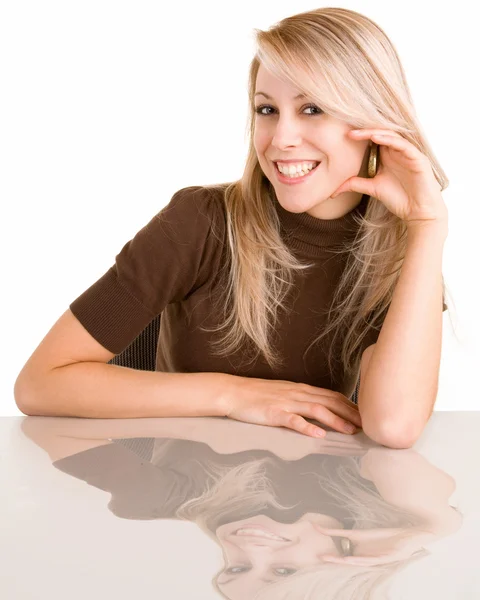 Usměvavá blonďatá dáma sedí u stolu — Stock fotografie