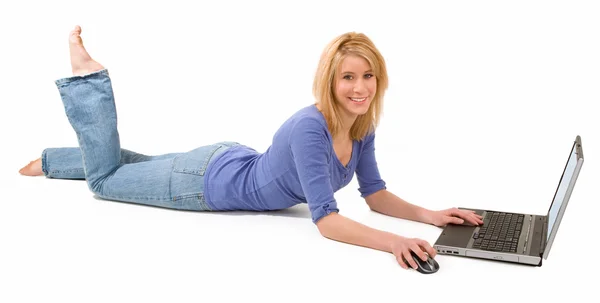 Женщина лежит и использует ноутбук — стоковое фото